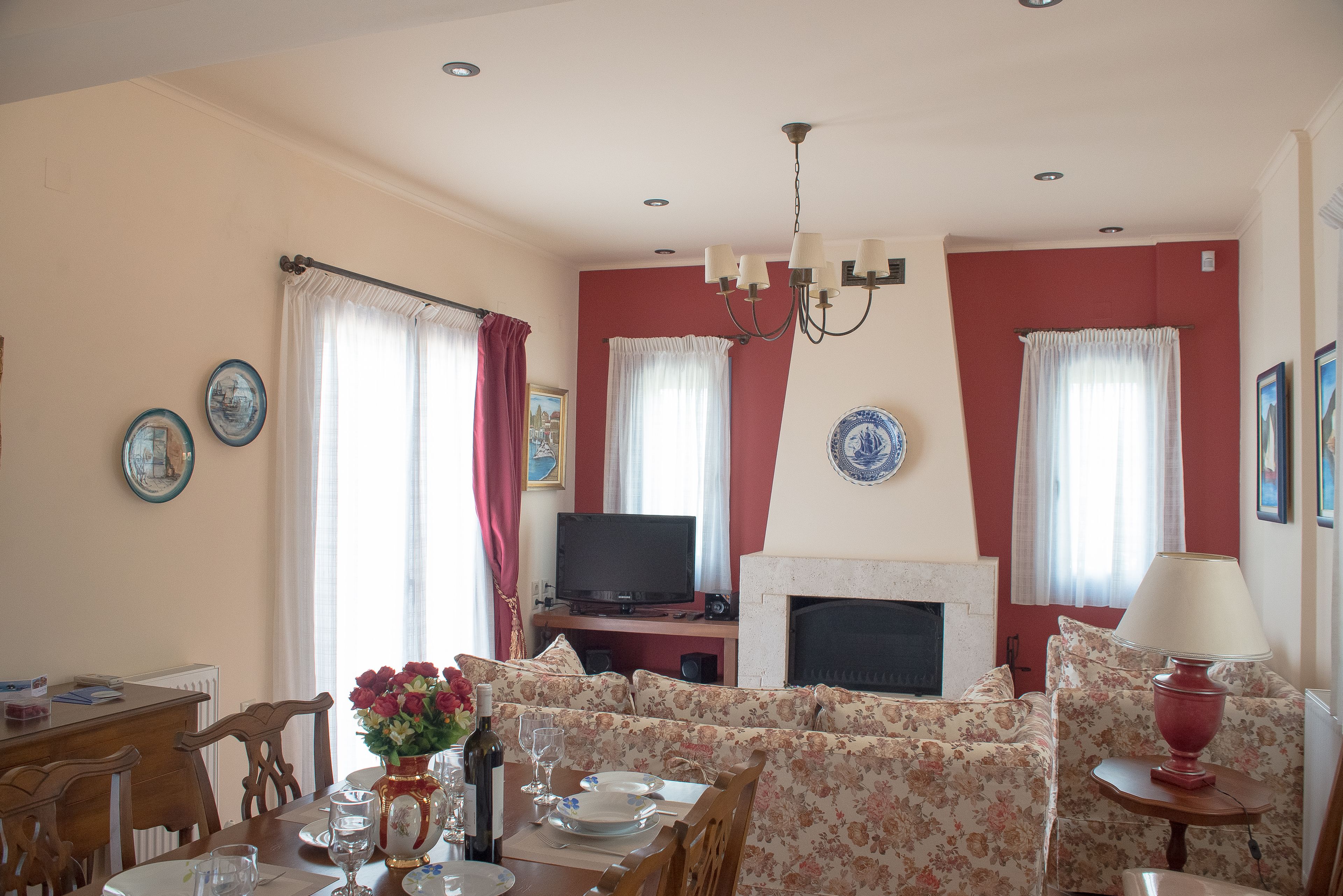 Ein Wohnzimmer mit Kamin, Sofa, Esstisch und Fernseher.