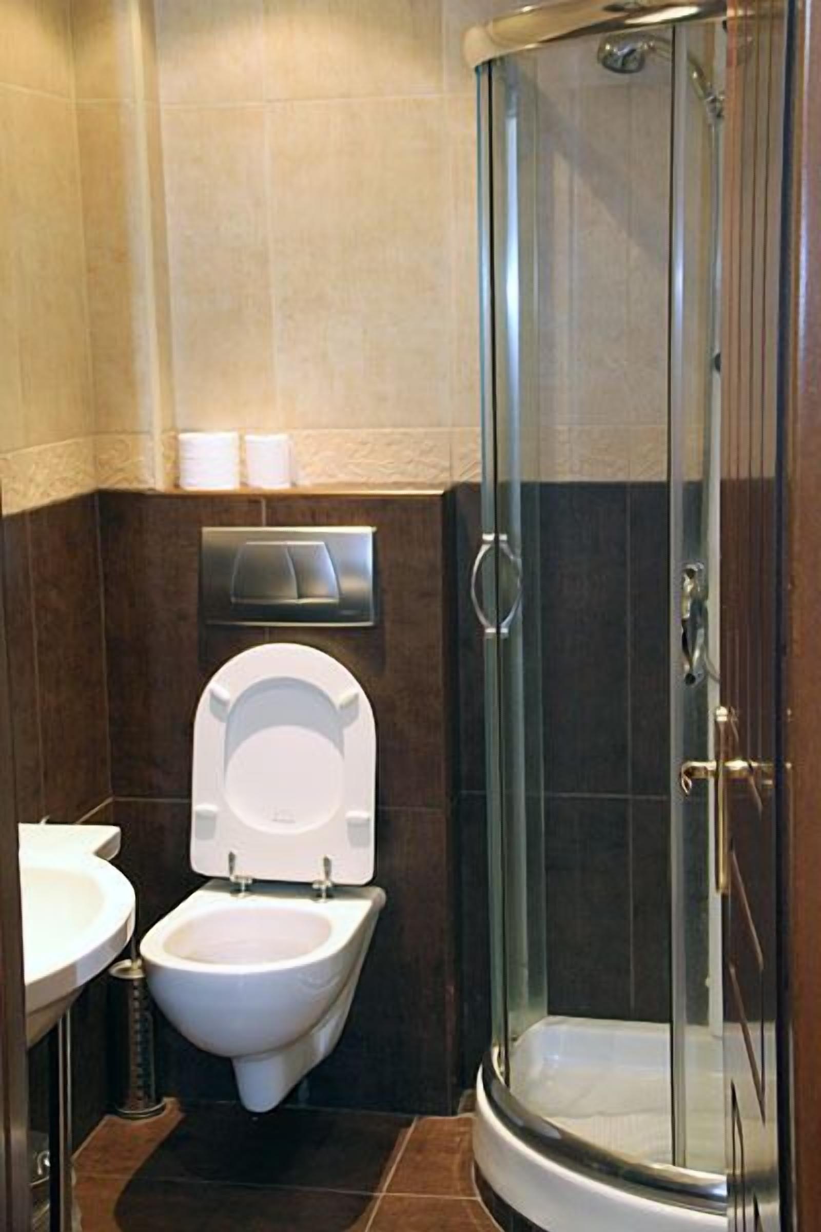 A modern bathroom with a glass-enclosed shower, a bidet, and a toilet.