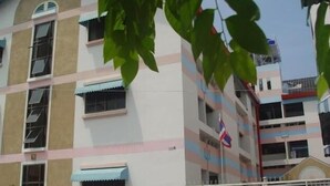 A multi-story building with balconies and a flag.