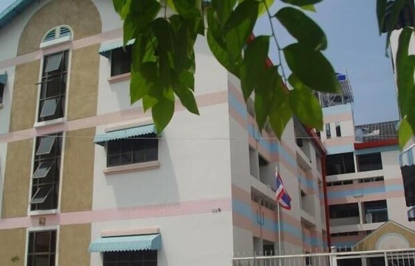 A multi-story building with balconies and a flag.