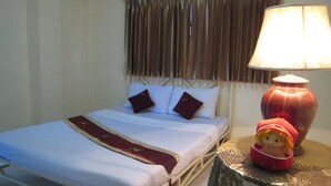 A hotel room with a bed, a lamp, and a decorative item on a side table.