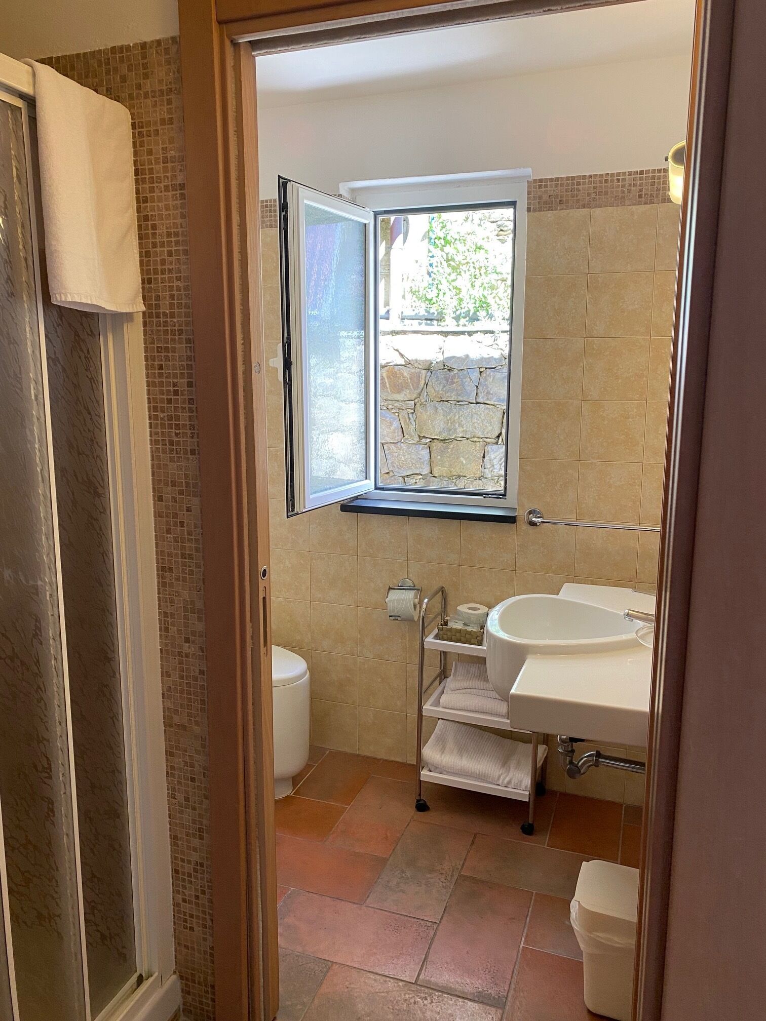 A bathroom with a window, a sink, and a toilet.