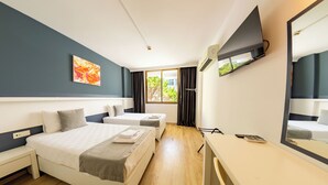 A hotel room with two beds, a desk, a TV, and a window with curtains. - Z Otel (Cesme)