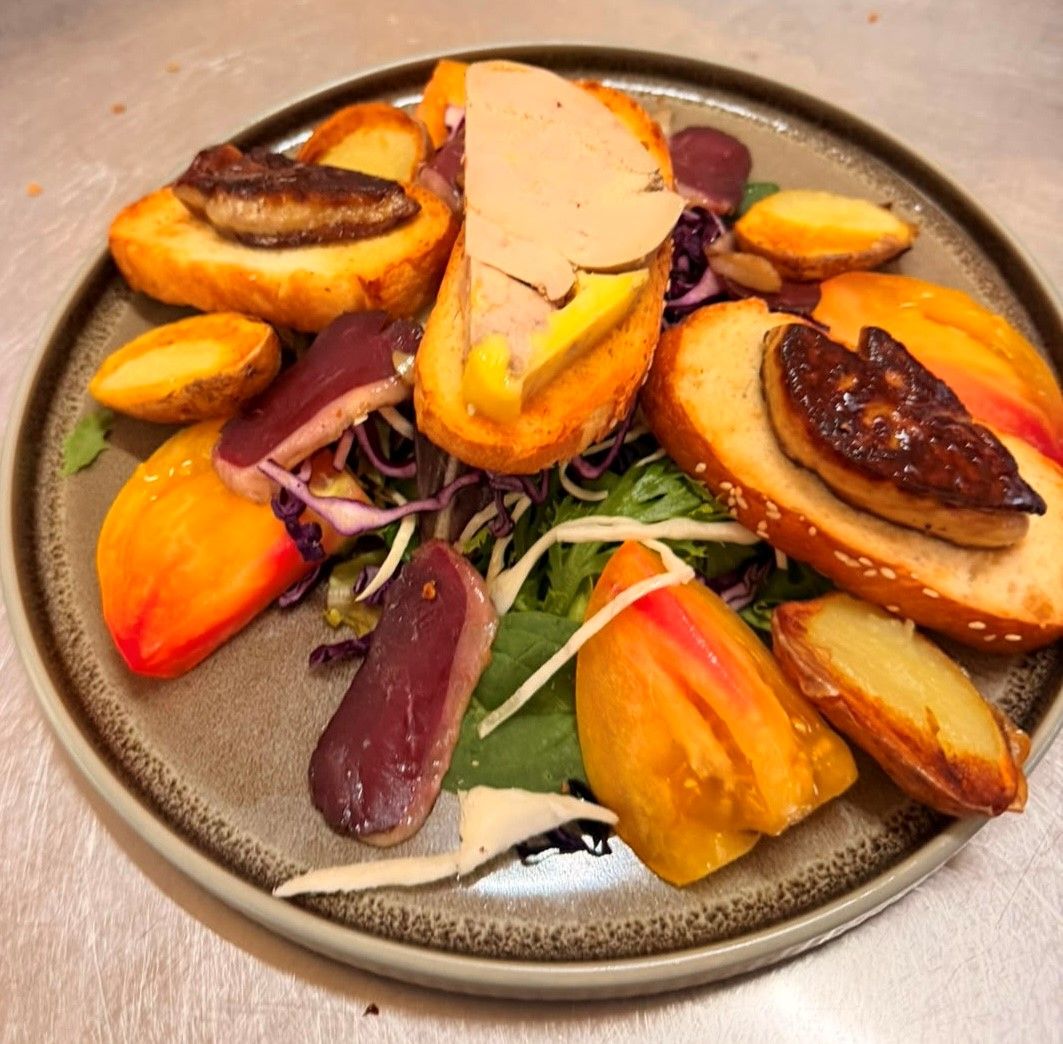 Une assiette de nourriture comprenant divers légumes et un morceau de viande.