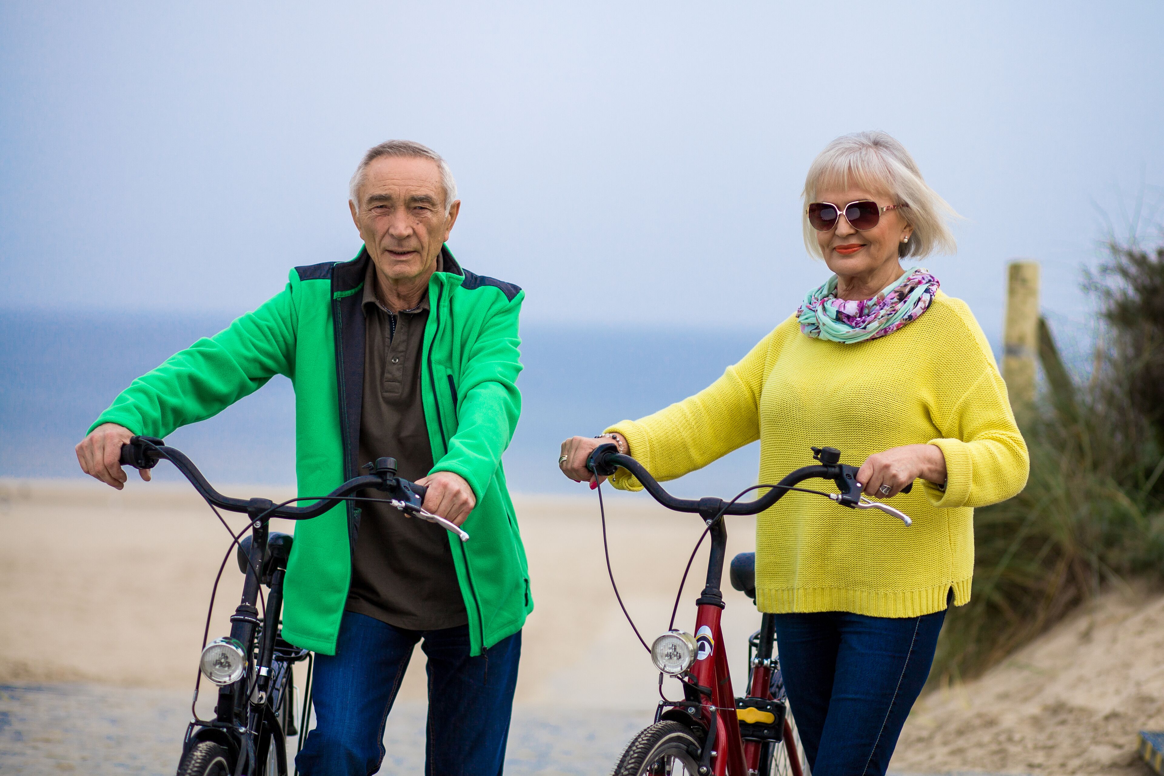 Two people on bicycles by the beach.
