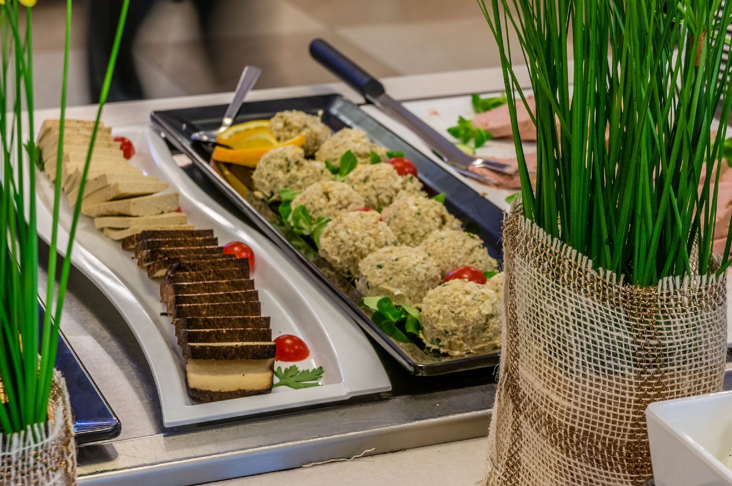 A buffet table with various food items, including meatballs, bread, and a dessert.