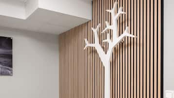 A bedroom with a bed, a white wall-mounted radiator, and a wooden slat partition.