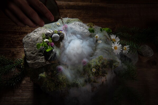A rustic stone arrangement with moss, flowers, and a mist effect. - SALZANO Hotel - Spa - Restaurant (Unterseen)