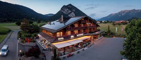 Un hotel con spa y restaurante, rodeado de montañas.