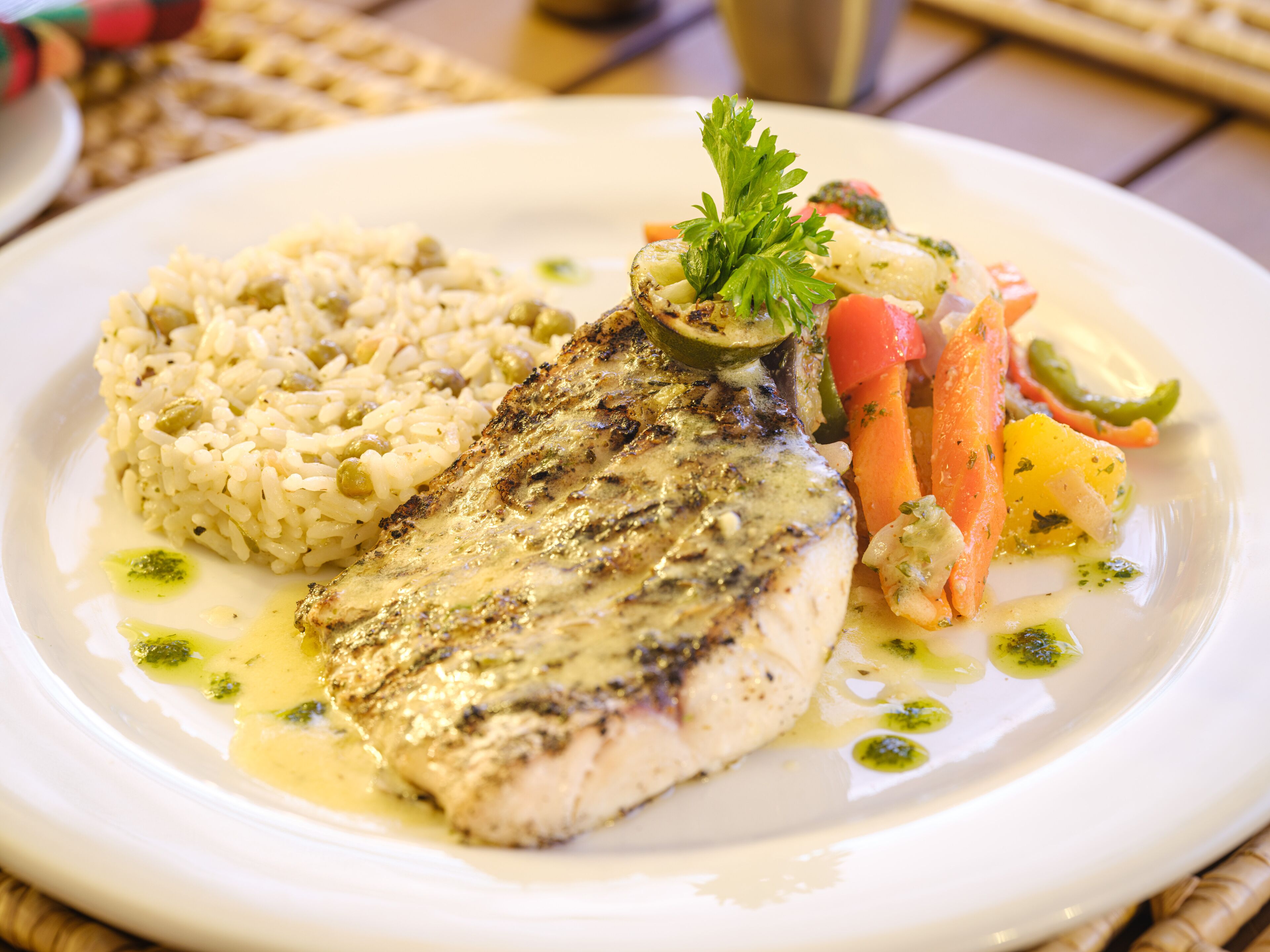 A plate of food with a fish fillet, rice, and vegetables.