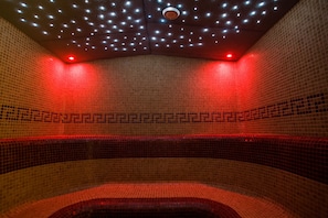 A tiled room with a curved bench and a circular skylight. - Hotel NAT Sarbinowo (Sarbinowo)