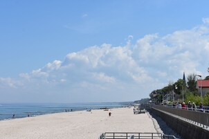 Una playa con un muro de piedra y un paseo marítimo.