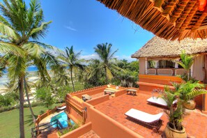 A rooftop pool area with lounge chairs, a pool, and a thatched-roof structure. - Swahili House Tiwi Beach - Private Oceanfront Boutique Villa Near Diani (Tiwi)