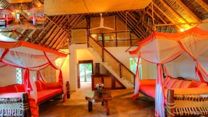 Una habitación con techo alto, una escalera y una cama con dosel.