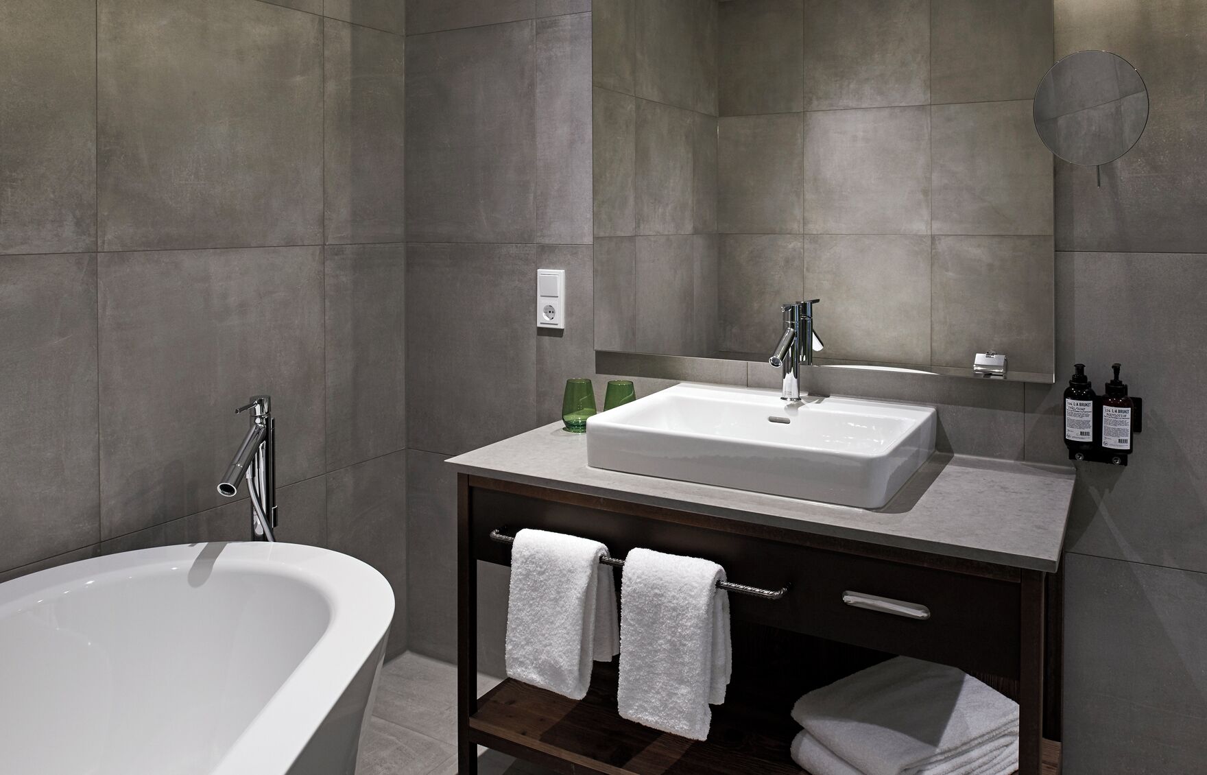 Une salle de bain moderne avec une baignoire sur pieds, un meuble-lavabo et un miroir.