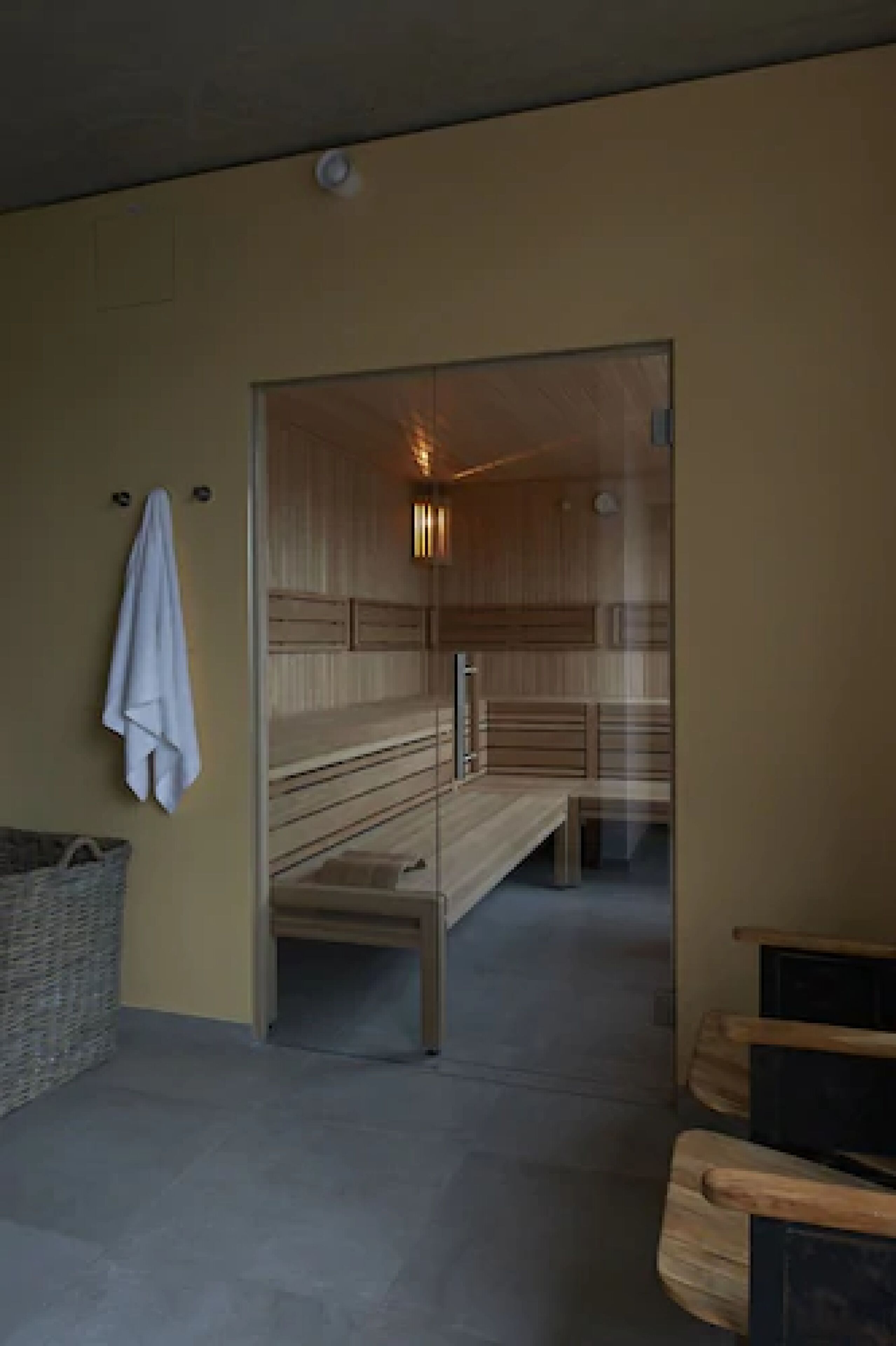 Un moderno espacio de spa con bancos de madera y una pared de vidrio.