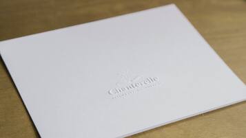 Un folleto blanco con texto en relieve y logotipo.