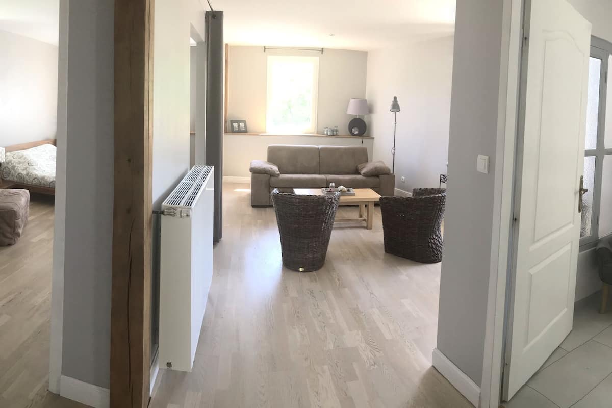 A spacious living area with a sofa, a coffee table, and a lamp.