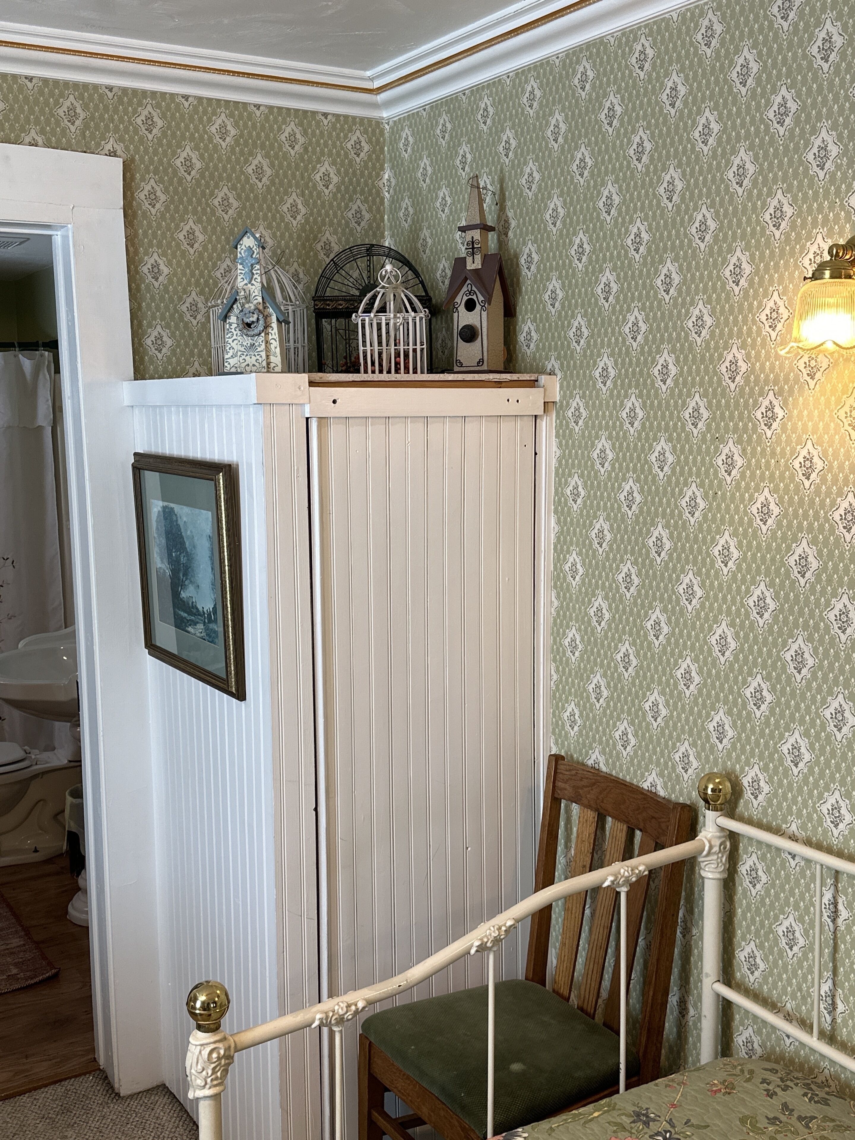 A room with a wooden chair, a white radiator, and a patterned wallpaper.