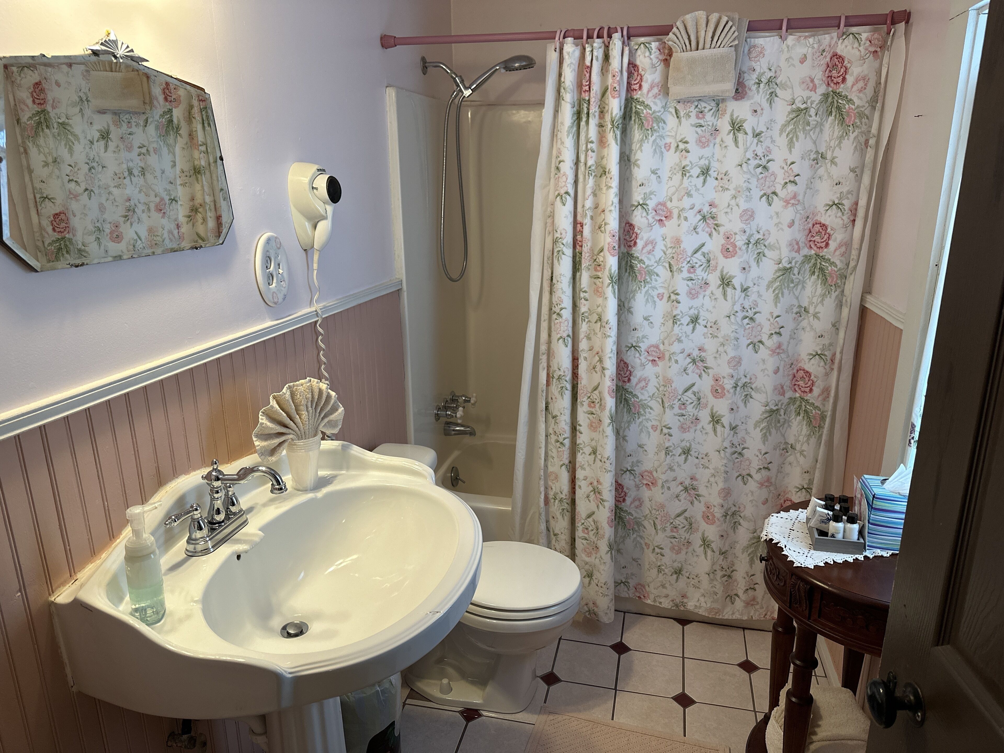 A bathroom with a sink, toilet, and shower.