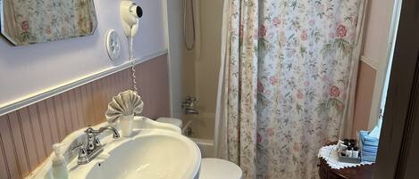 A bathroom with a sink, toilet, and shower.