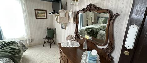 Un dormitorio con un espejo grande, un aparador, una silla y una cama.