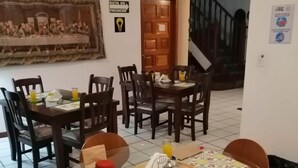 A dining area with a round table, chairs, and a painting on the wall. - Novohostal B&B (Guatemala City)