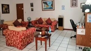 A living room with a sofa set, a small table, a globe, and a lamp. - Novohostal B&B (Guatemala City)