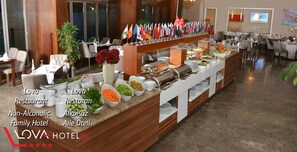 A buffet setup in a hotel with multiple flags, a variety of food items, and a sign indicating it's a non-alcoholic family hotel. - Lova Hotel SPA (Yalova)