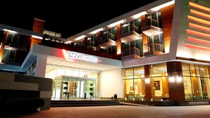 A modern hotel with a prominent entrance, multiple balconies, and a well-lit facade. - Lova Hotel SPA (Yalova)