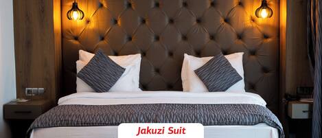 Une suite avec jacuzzi, dotée d’une tête de lit capitonnée, de deux lampes de chevet et d’un lit avec une literie à motifs.