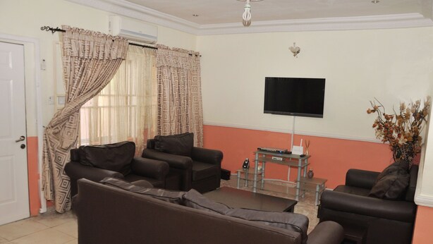 Ein Wohnzimmer mit zwei Sofas, einem Couchtisch und einem flachbildfernseher an der Wand.