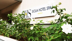 Un letrero de hotel con el nombre 'SICILIA HOTEL SPA' y una clasificación de tres estrellas.