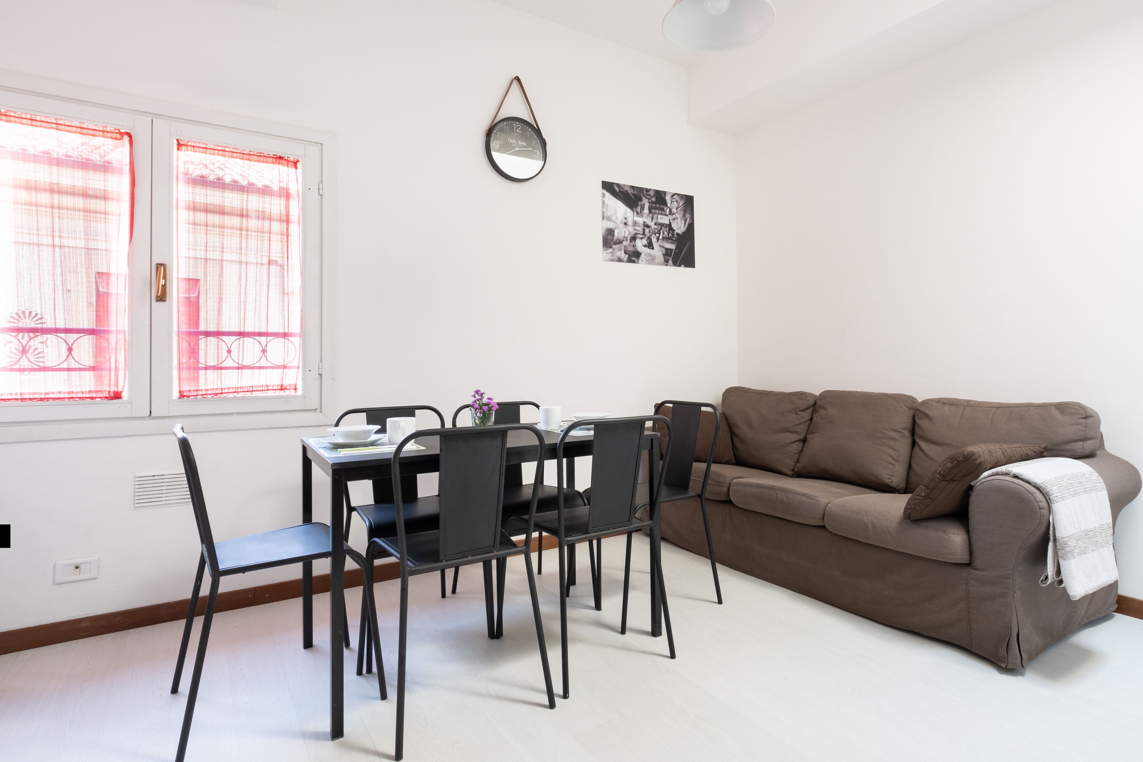 A dining area with a table, chairs, and a couch.