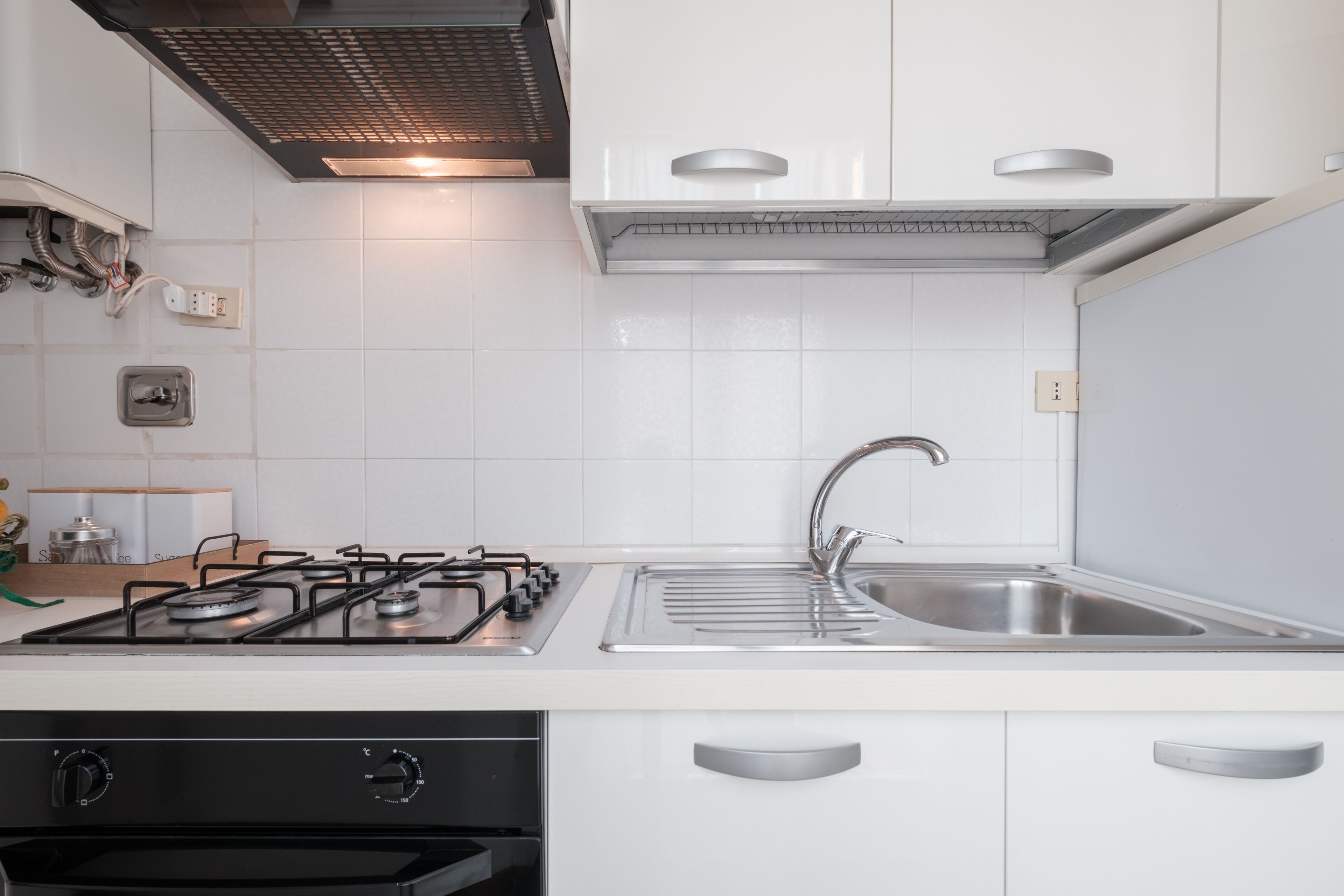 A modern kitchen with white cabinets, stainless steel appliances, and a double sink.