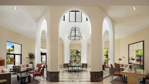 A spacious lobby with high ceilings, arched columns, a central chandelier, and comfortable seating areas. - Pine Cliffs Ocean Suites, a Luxury Collection Resort & Spa (Albufeira)