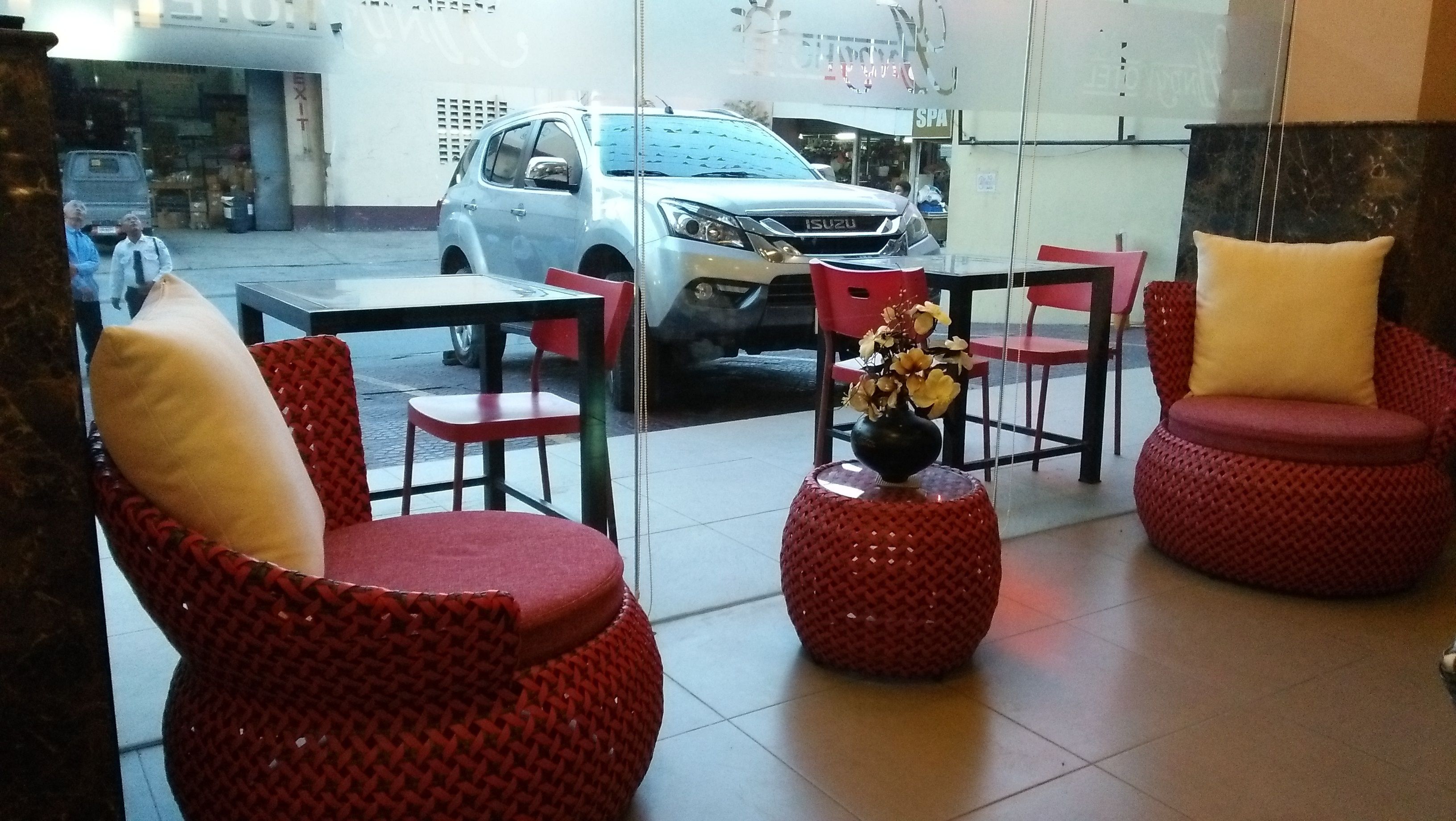 A seating area with red chairs and a table, a car parked outside, and a building with a sign that reads "SPA".