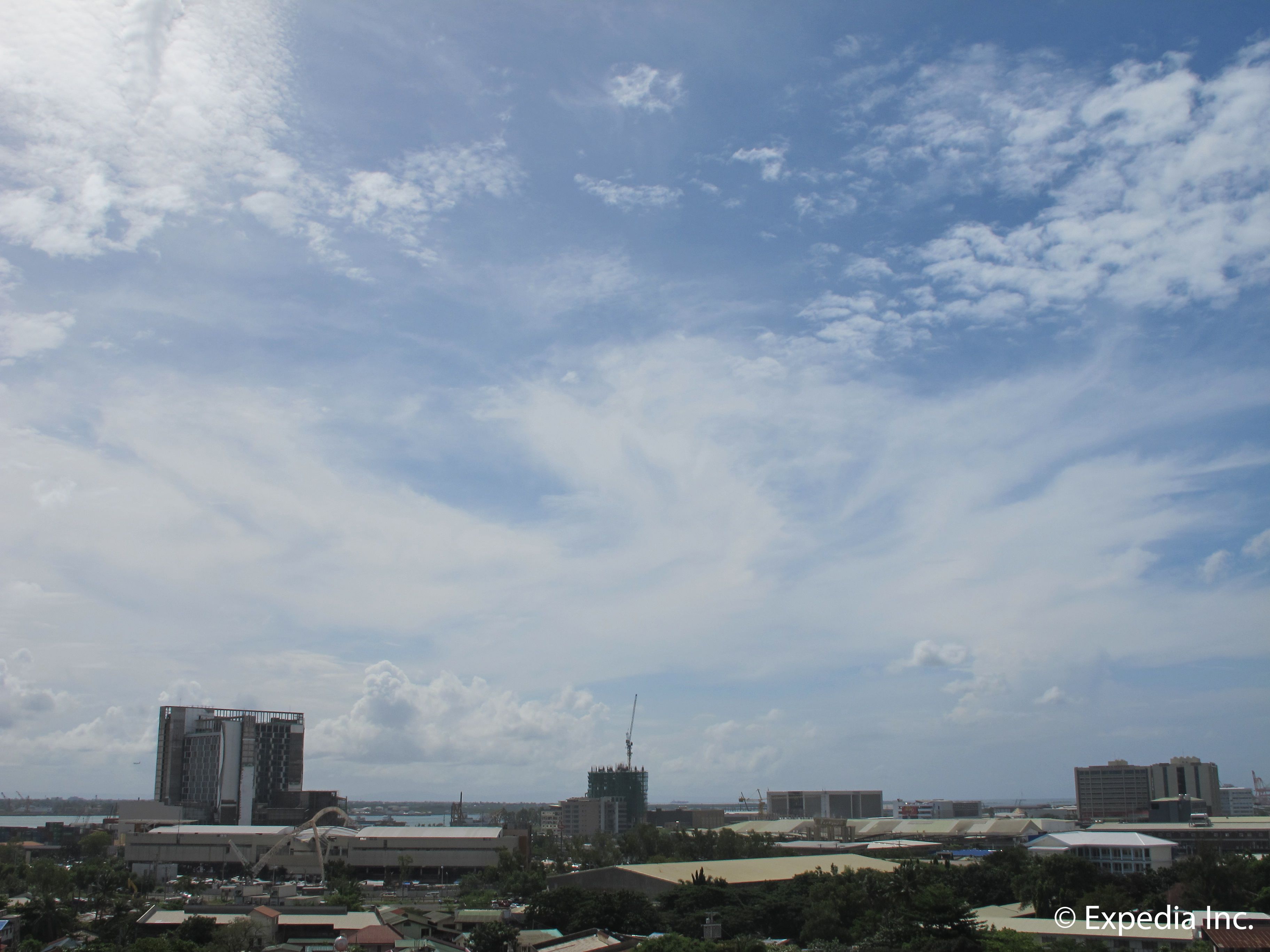 A cityscape with various buildings, including a tall skyscraper and several mid-rise structures.