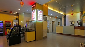 L’intérieur d’un restaurant, avec un présentoir de menus, un réfrigérateur Coca-Cola et un distributeur automatique.