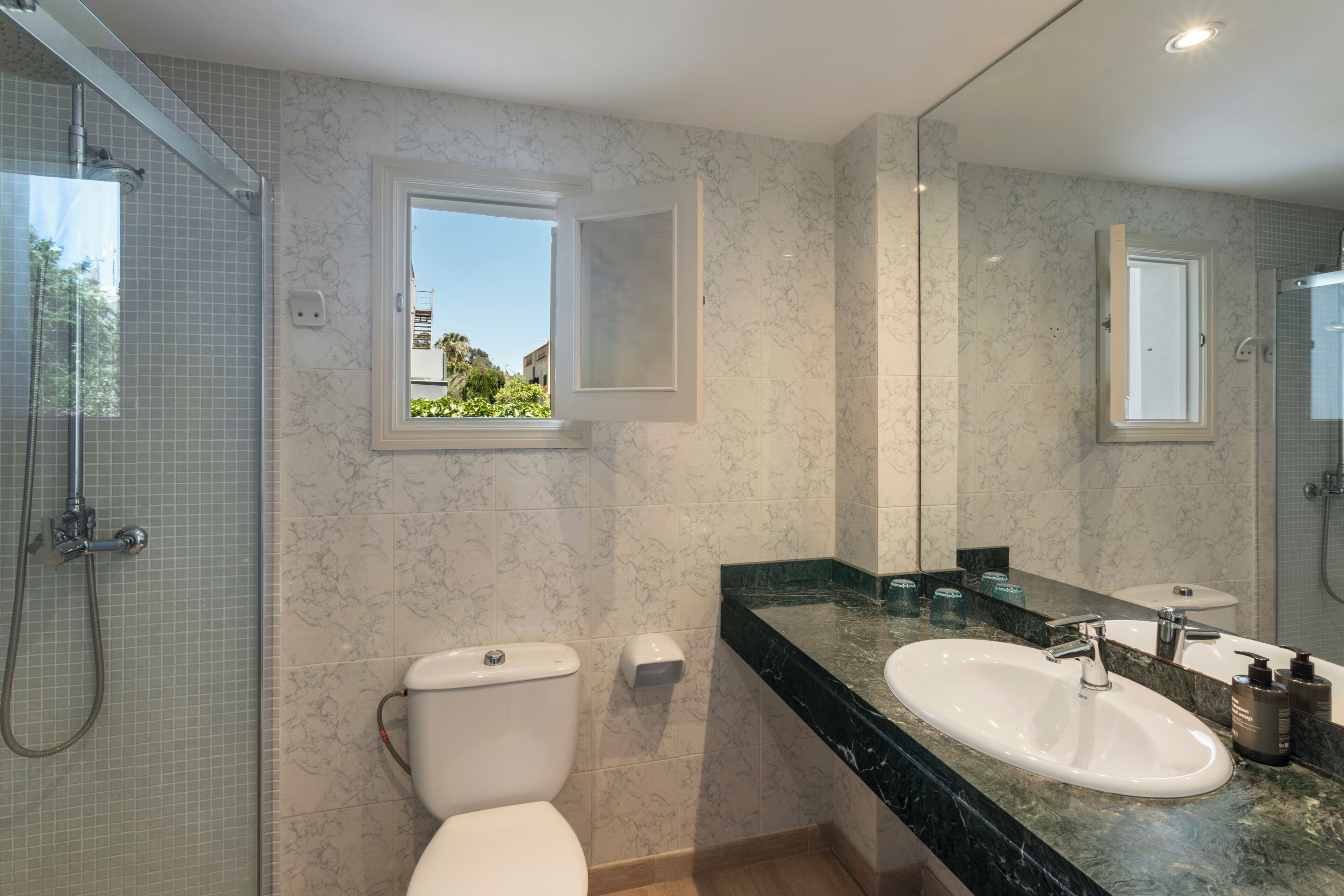A bathroom with a toilet, sink, and shower.
