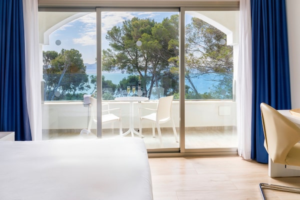 Minibar, escritorio, cortinas blackout y tabla de planchar con plancha