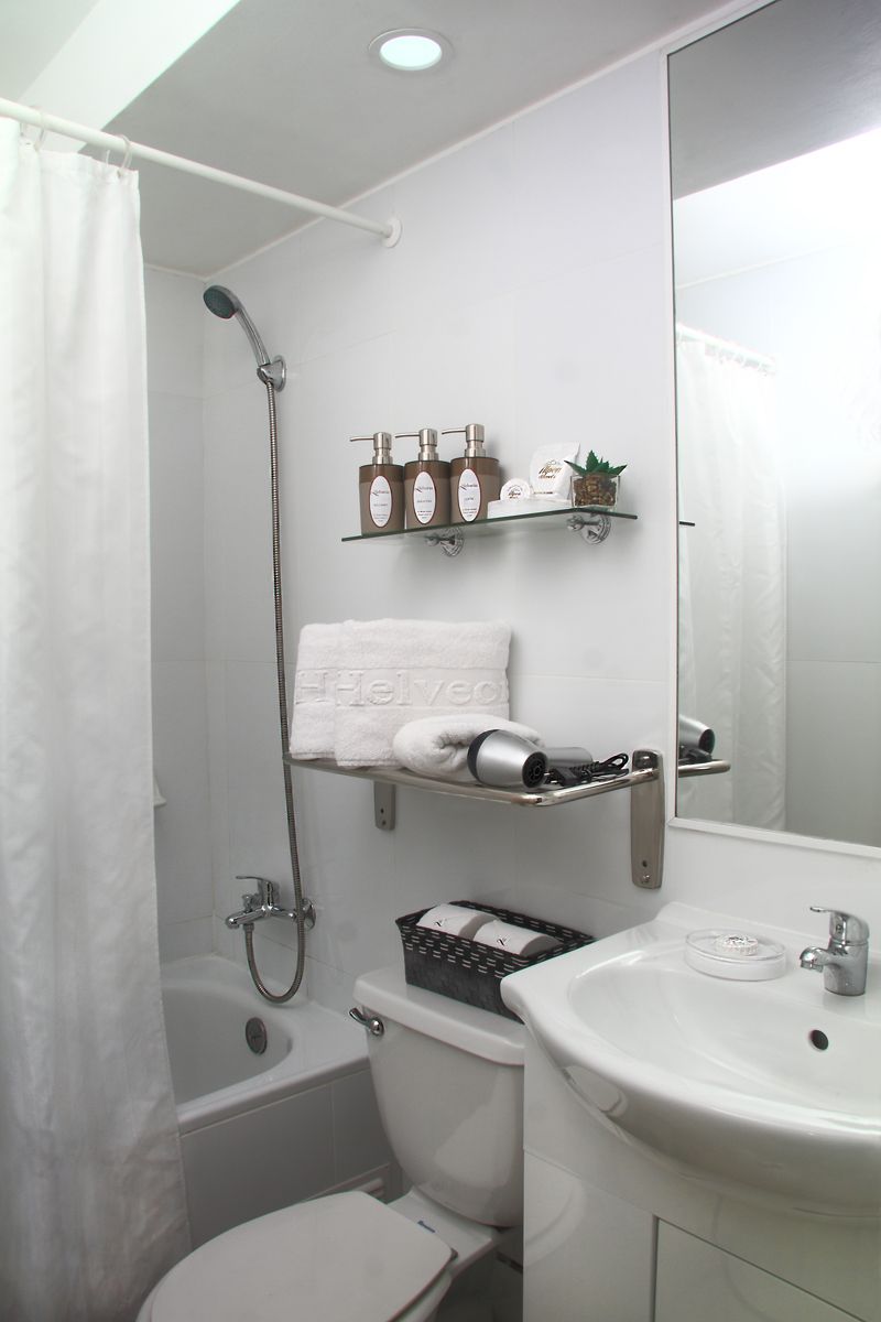 Une salle de bain équipée d’une douche, de toilettes, d’un lavabo et d’un miroir.