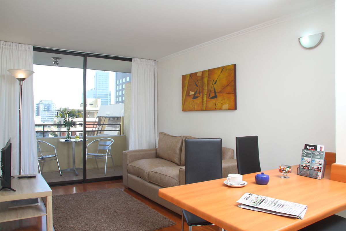 Une chambre d’hôtel moderne avec balcon, un canapé, une table avec un menu et une vue sur la ville.
