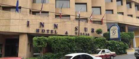 A building with the sign "INN SUR HOTEL & VILLAS".