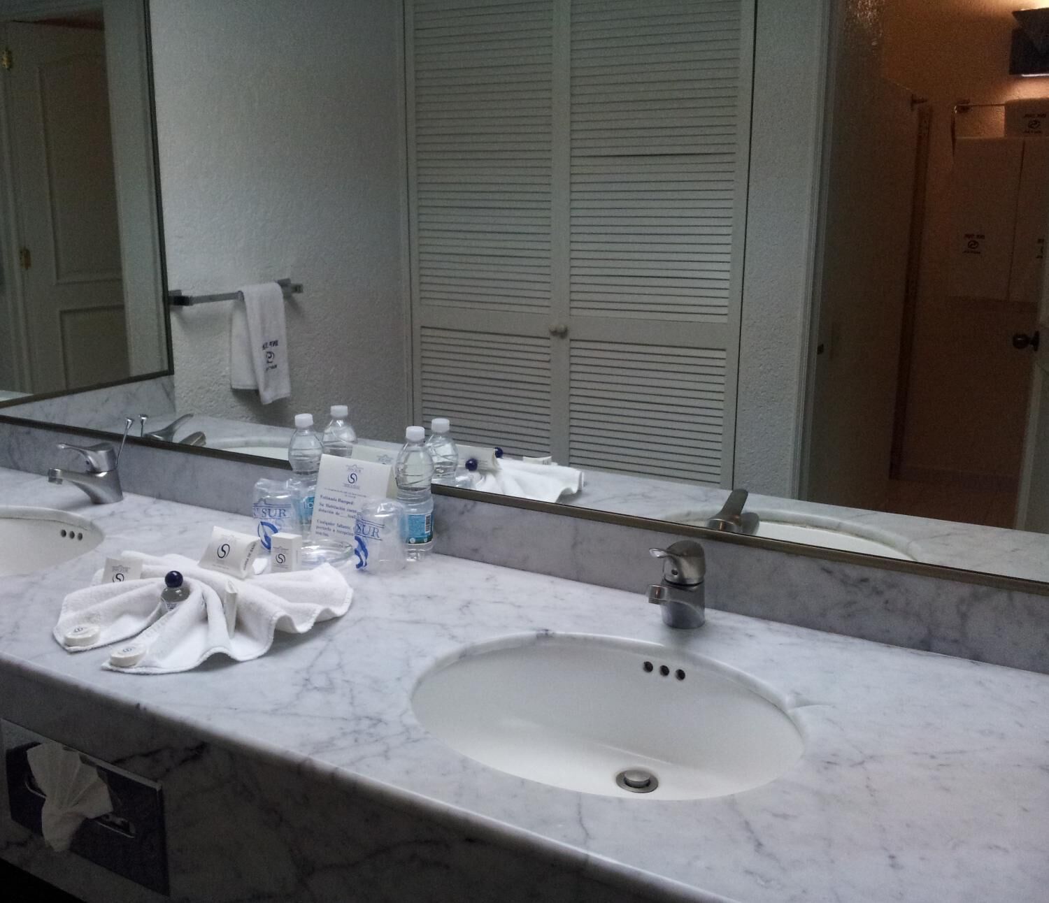Une salle de bain avec deux lavabos, un miroir et des articles de toilette.