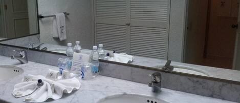 Une salle de bain avec deux lavabos, un miroir et des articles de toilette.