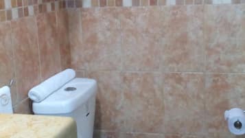 Un baño con inodoro, perchero y ducha.