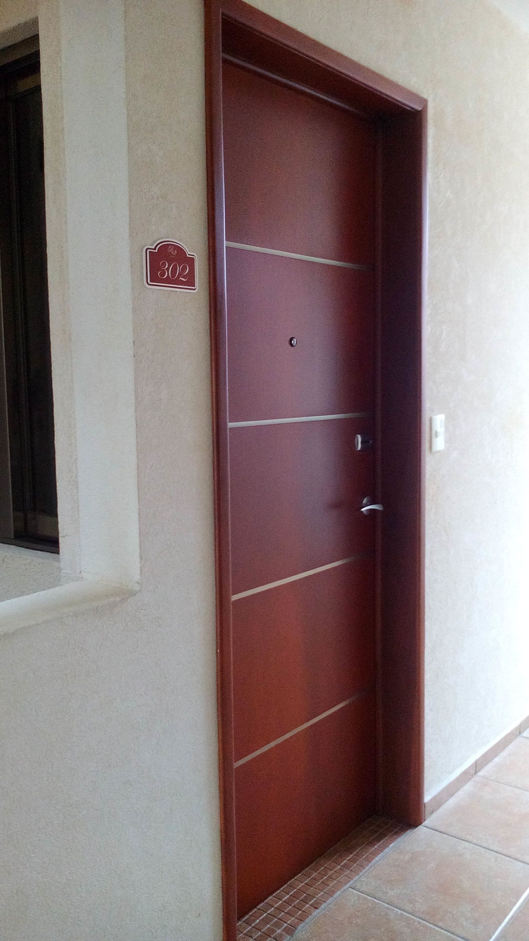 Uma porta de madeira com placa indicando o quarto 302.