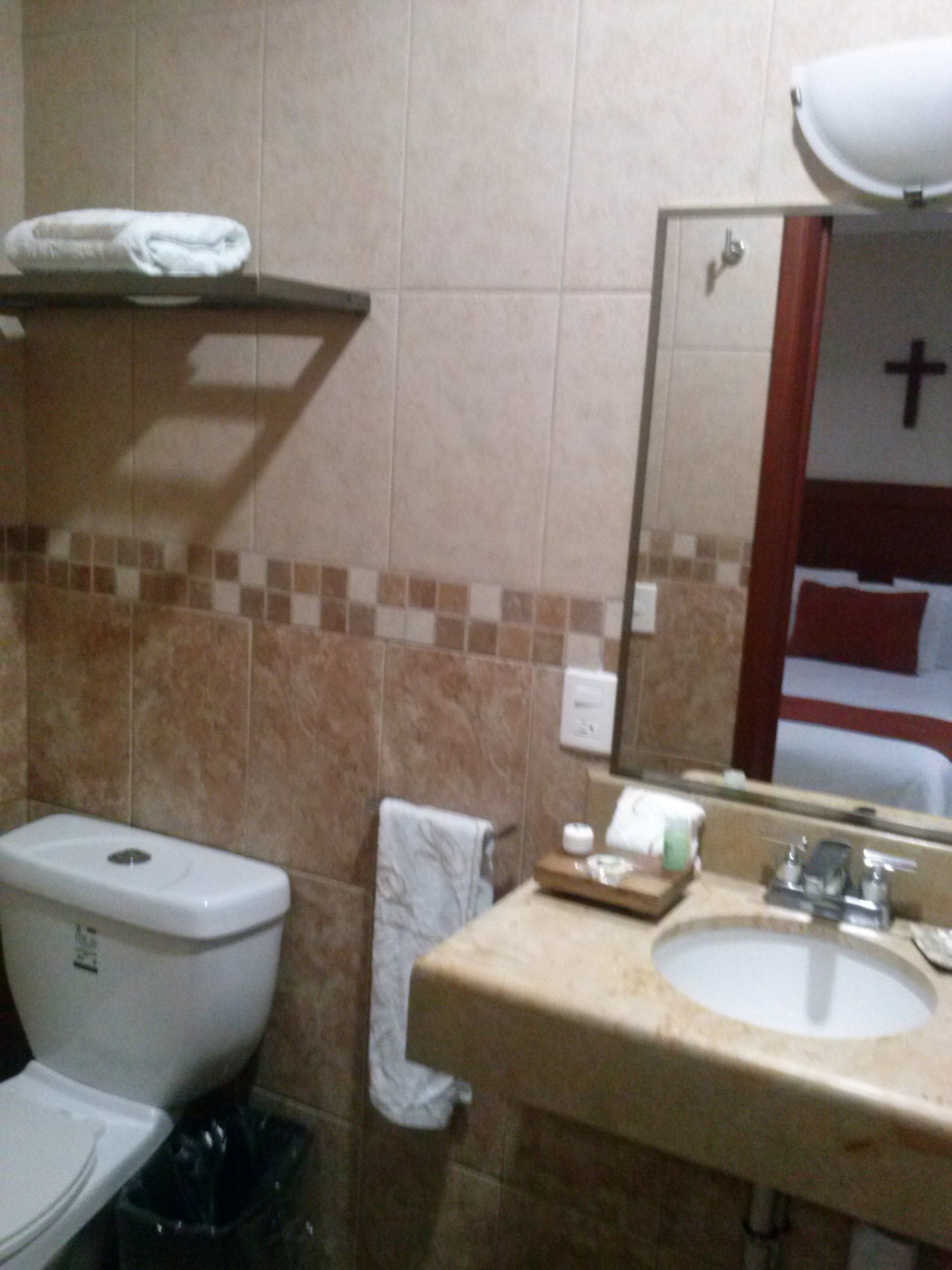 Une salle de bain équipée de toilettes, d’un lavabo et d’un porte-serviettes.