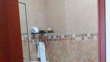 Un baño pequeño con inodoro, lavamanos y espejo.